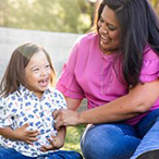 ther smiling while playing with her son, who has Down syndrome.